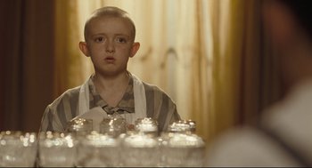 Movie still from “The Boy in the Striped Pajamas” (2008), directed by Mark Herman – A young boy in a striped shirt looking at the camera; Close Up shot, Over the shoulder angle