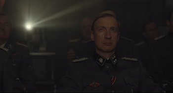 Movie still from “The Boy in the Striped Pajamas” (2008), directed by Mark Herman – A man in a military uniform is in a dark room; Close Up shot, Low angle