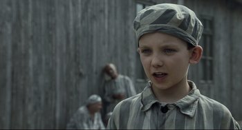 Movie still from “The Boy in the Striped Pajamas” (2008), directed by Mark Herman – A young boy wearing a striped shirt and a hat; Close Up shot, Over the shoulder angle
