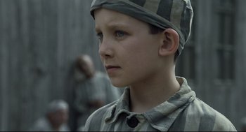 Movie still from “The Boy in the Striped Pajamas” (2008), directed by Mark Herman – A young boy wearing a hat and looking to his left; Close Up shot, High angle