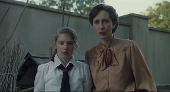 Movie still from “The Boy in the Striped Pajamas” (2008), directed by Mark Herman – A woman standing next to a young girl in front of a building; Medium shot, Low angle