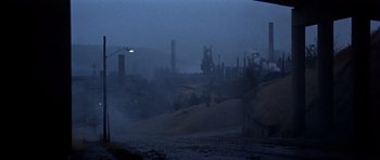 Movie still from “The Deer Hunter” (1978), directed by Michael Cimino – A view of an industrial area at night with fog; Extreme Wide shot, High angle