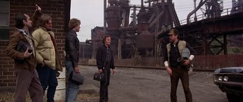 Movie still from “The Deer Hunter” (1978), directed by Michael Cimino – A group of people standing next to each other on a street; Wide shot, High angle