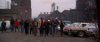 Movie still from “The Deer Hunter” (1978), directed by Michael Cimino – A group of people walking down a street; Wide shot, High angle