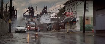 Movie still from “The Deer Hunter” (1978), directed by Michael Cimino – A fire truck driving down the street in the rain; Extreme Wide shot, High angle