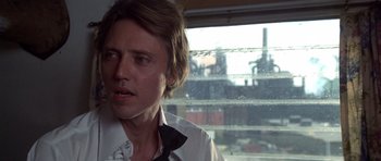 Movie still from “The Deer Hunter” (1978), directed by Michael Cimino – A man in white shirt and tie looking out of a window; Close Up shot, Over the shoulder angle