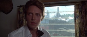 Movie still from “The Deer Hunter” (1978), directed by Michael Cimino – A young man in white shirt and tie looking out a window; Close Up shot, Low angle