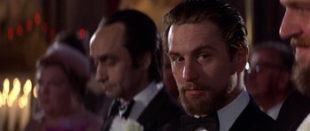 Movie still from “The Deer Hunter” (1978), directed by Michael Cimino – A man in a suit and tie next to another man in a suit and tie; Close Up shot, Over the shoulder angle