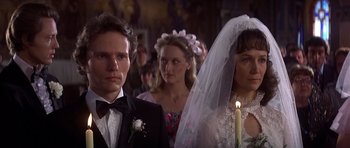 A man and a woman standing in front of a bride and groom