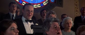 Movie still from “The Deer Hunter” (1978), directed by Michael Cimino – A group of people that are in front of a stained glass window; Close Up shot, Low angle