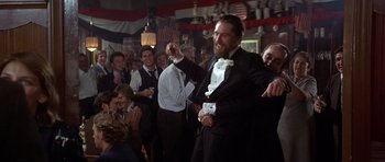 Movie still from “The Deer Hunter” (1978), directed by Michael Cimino – A man in a suit and bow tie is dancing in front of a crowd; Medium shot, Low angle
