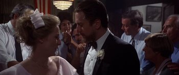 Movie still from “The Deer Hunter” (1978), directed by Michael Cimino – A man and a woman in formal wear standing next to each other in front of a crowd; Close Up shot, Over the shoulder angle