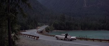 Movie still from “The Deer Hunter” (1978), directed by Michael Cimino – A man walking down the street next to a car; Extreme Wide shot, High angle