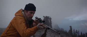 Movie still from “The Deer Hunter” (1978), directed by Michael Cimino – A man with a rifle in a field; Medium shot, Low angle