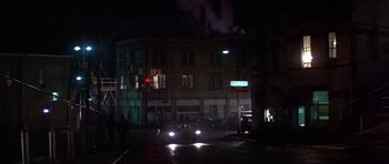 Movie still from “The Deer Hunter” (1978), directed by Michael Cimino – A car is stopped at a red light at night; Extreme Wide shot, High angle