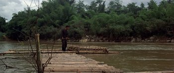 Movie still from “The Deer Hunter” (1978), directed by Michael Cimino – A man standing on top of a raft on a river; Wide shot, High angle