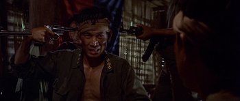 Movie still from “The Deer Hunter” (1978), directed by Michael Cimino – A man with a bandage on his head is being shaved; Medium shot, Over the shoulder angle