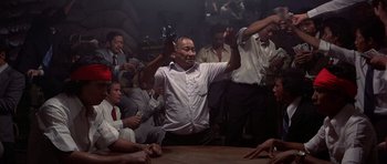 Movie still from “The Deer Hunter” (1978), directed by Michael Cimino – A group of men sitting around a table; Wide shot, Low angle