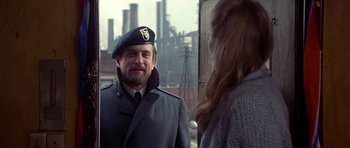 Movie still from “The Deer Hunter” (1978), directed by Michael Cimino – A man in a military uniform talking to a woman in front of an industrial building; Medium shot, Over the shoulder angle