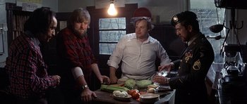 Movie still from “The Deer Hunter” (1978), directed by Michael Cimino – Two men standing at a table preparing food for dinner; Medium shot, High angle