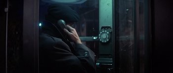 Movie still from “The Deer Hunter” (1978), directed by Michael Cimino – A man talking on a phone next to a phone booth; Close Up shot, Over the shoulder angle