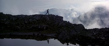 Movie still from “The Deer Hunter” (1978), directed by Michael Cimino – A person is standing on top of a mountain; Extreme Wide shot, Low angle