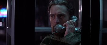 Movie still from “The Deer Hunter” (1978), directed by Michael Cimino – A man talking on a phone in a dark room; Close Up shot, Low angle