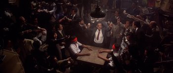 Movie still from “The Deer Hunter” (1978), directed by Michael Cimino – A group of people sitting around a table; Wide shot, Overhead angle