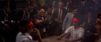 Movie still from “The Deer Hunter” (1978), directed by Michael Cimino – A group of men standing around a table; Wide shot, High angle
