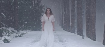 Movie still from “10 Days of a Bad Man” (2023), directed by Uluç Bayraktar – A woman in a long white dress standing in the snow; Wide shot, Low angle