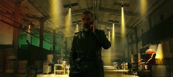 Movie still from “10 Days of a Bad Man” (2023), directed by Uluç Bayraktar – A man wearing a black leather jacket talking on a cell phone; Medium shot, Low angle