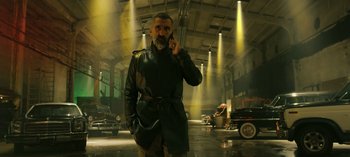 Movie still from “10 Days of a Bad Man” (2023), directed by Uluç Bayraktar – A man wearing a leather jacket talking on a cell phone; Medium shot, Low angle