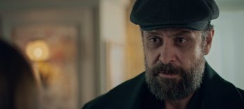 Movie still from “10 Days of a Bad Man” (2023), directed by Uluç Bayraktar – A person wearing a hat; Close Up shot, Over the shoulder angle