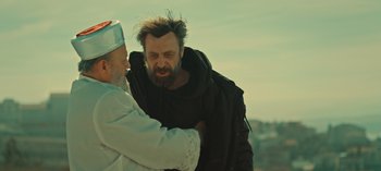 Movie still from “10 Days of a Bad Man” (2023), directed by Uluç Bayraktar – A man with a beard is being hugged by a man with a beard; Medium shot, Over the shoulder angle