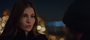 Movie still from “10 Days of a Bad Man” (2023), directed by Uluç Bayraktar – A woman's face in front of a city skyline at night; Close Up shot, Over the shoulder angle