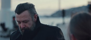 Movie still from “10 Days of a Bad Man” (2023), directed by Uluç Bayraktar – A person wearing a jacket; Close Up shot, Over the shoulder angle