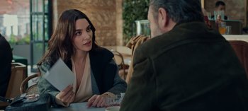 Movie still from “10 Days of a Bad Man” (2023), directed by Uluç Bayraktar – A woman sitting at a table talking to a man; Medium shot, Over the shoulder angle