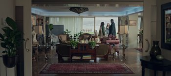 Movie still from “10 Days of a Bad Man” (2023), directed by Uluç Bayraktar – A living room filled with lots of furniture and large windows; Extreme Wide shot, High angle