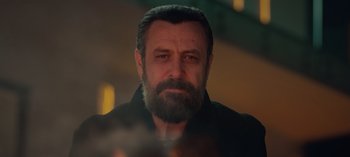 Movie still from “10 Days of a Bad Man” (2023), directed by Uluç Bayraktar – A person with a beard; Close Up shot, Low angle