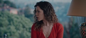 Movie still from “10 Days of a Bad Man” (2023), directed by Uluç Bayraktar – A woman in a red shirt is looking at the camera; Close Up shot, High angle
