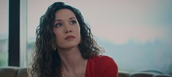 Movie still from “10 Days of a Bad Man” (2023), directed by Uluç Bayraktar – A woman in a red shirt is looking up; Close Up shot, Low angle