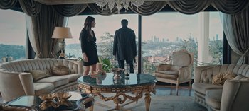 Movie still from “10 Days of a Bad Man” (2023), directed by Uluç Bayraktar – A man and a woman standing in front of a window; Wide shot, Low angle