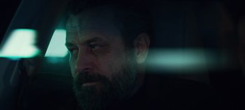 Movie still from “10 Days of a Bad Man” (2023), directed by Uluç Bayraktar – A man with a long beard is looking into the distance; Close Up shot, Low angle