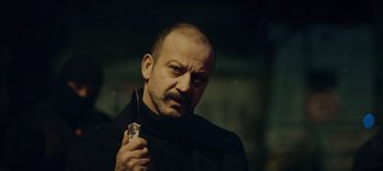 Movie still from “10 Days of a Bad Man” (2023), directed by Uluç Bayraktar – A person holding a knife in his hand; Close Up shot, Low angle