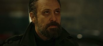 Movie still from “10 Days of a Bad Man” (2023), directed by Uluç Bayraktar – A person with a beard; Close Up shot, Low angle