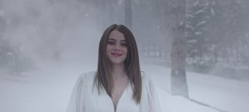 Movie still from “10 Days of a Bad Man” (2023), directed by Uluç Bayraktar – A beautiful young lady wearing a white dress in the snow; Close Up shot, Over the shoulder angle