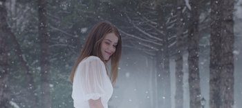 Movie still from “10 Days of a Bad Man” (2023), directed by Uluç Bayraktar – A woman in a white dress standing in the snow; Medium shot, Over the shoulder angle