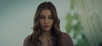 Movie still from “10 Days of a Bad Man” (2023), directed by Uluç Bayraktar – A beautiful young woman with long brown hair; Close Up shot, Low angle