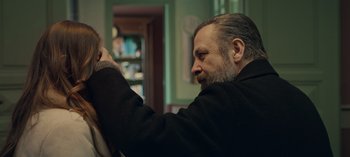 Movie still from “10 Days of a Bad Man” (2023), directed by Uluç Bayraktar – A man with a goatee is looking at a woman's hair; Close Up shot, Over the shoulder angle