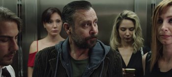 Movie still from “10 Days of a Good Man” (2023), directed by Uluç Bayraktar – A group of people standing next to each other in a room; Close Up shot, Low angle